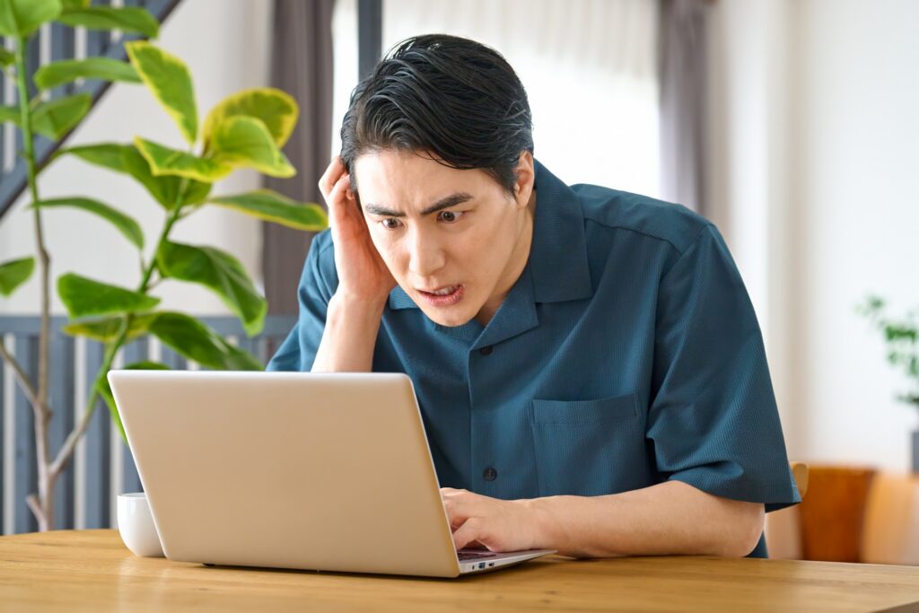 パソコンの前でDTMに悩んでいる人物のイラスト。画面に複雑なDAW画面が映っているイメージ